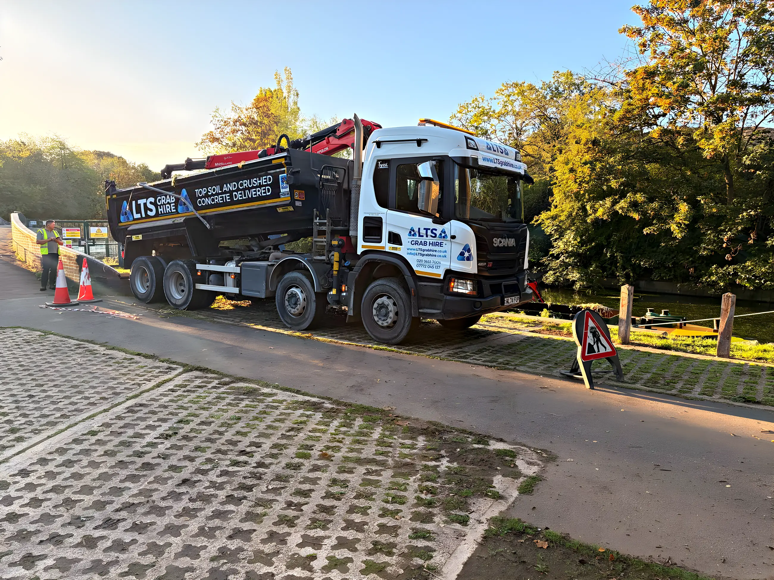 The eight-wheel Scania grab lorry on a towpath job, cones out