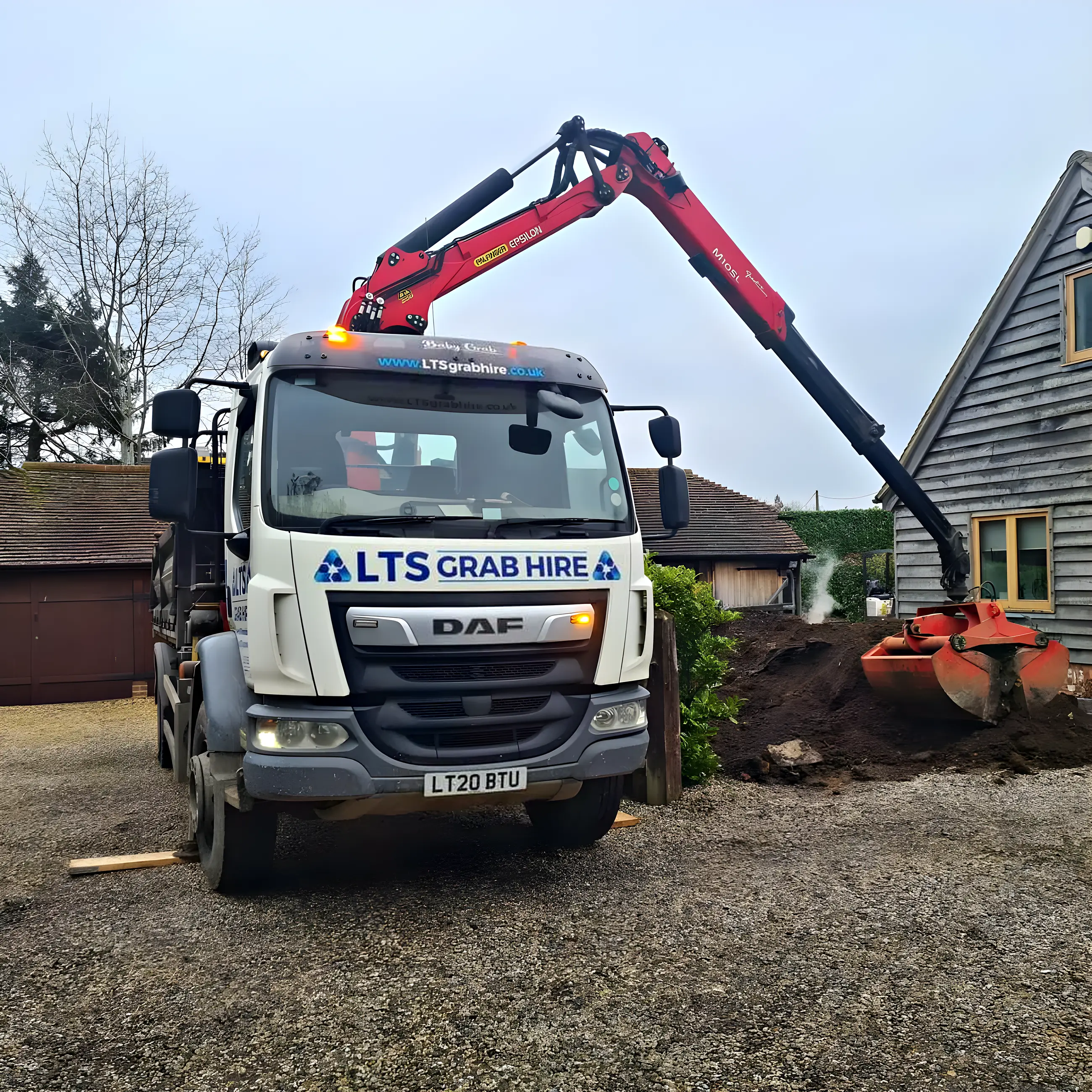 A grab bucket digging into a heap of excavated soil