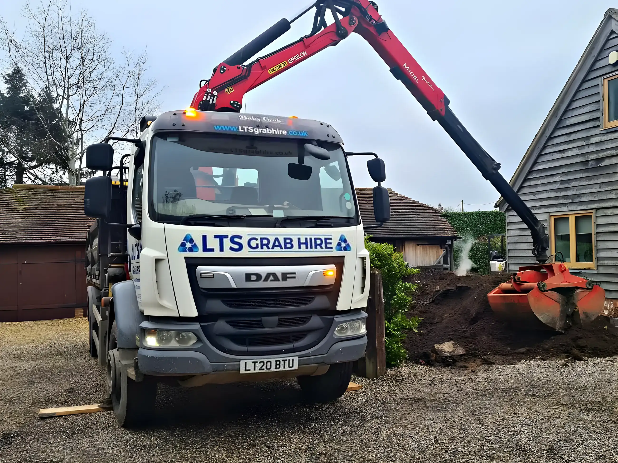 A grab bucket digging into a heap of excavated soil