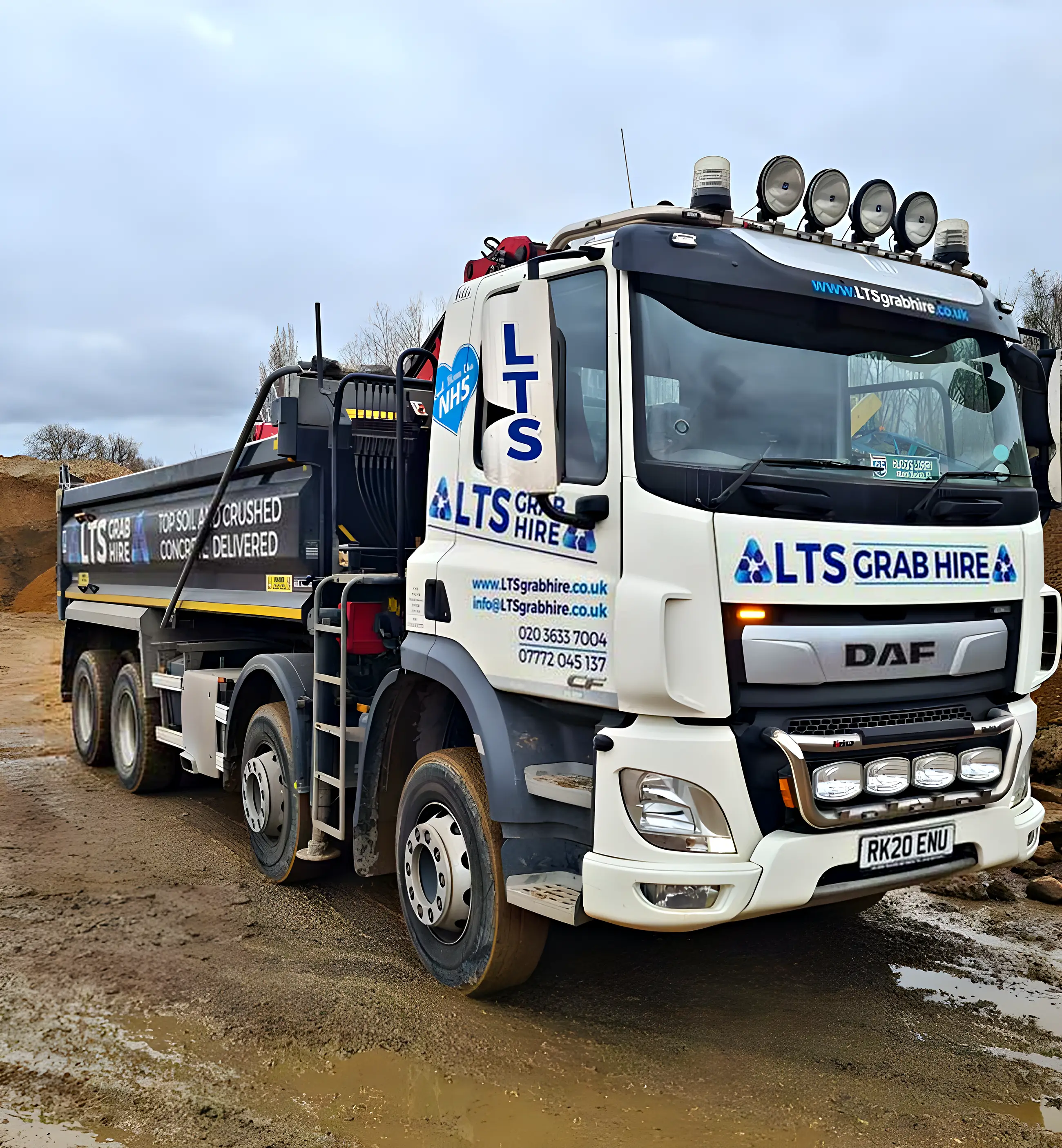 A grab lorry at the yard with the arm raised
