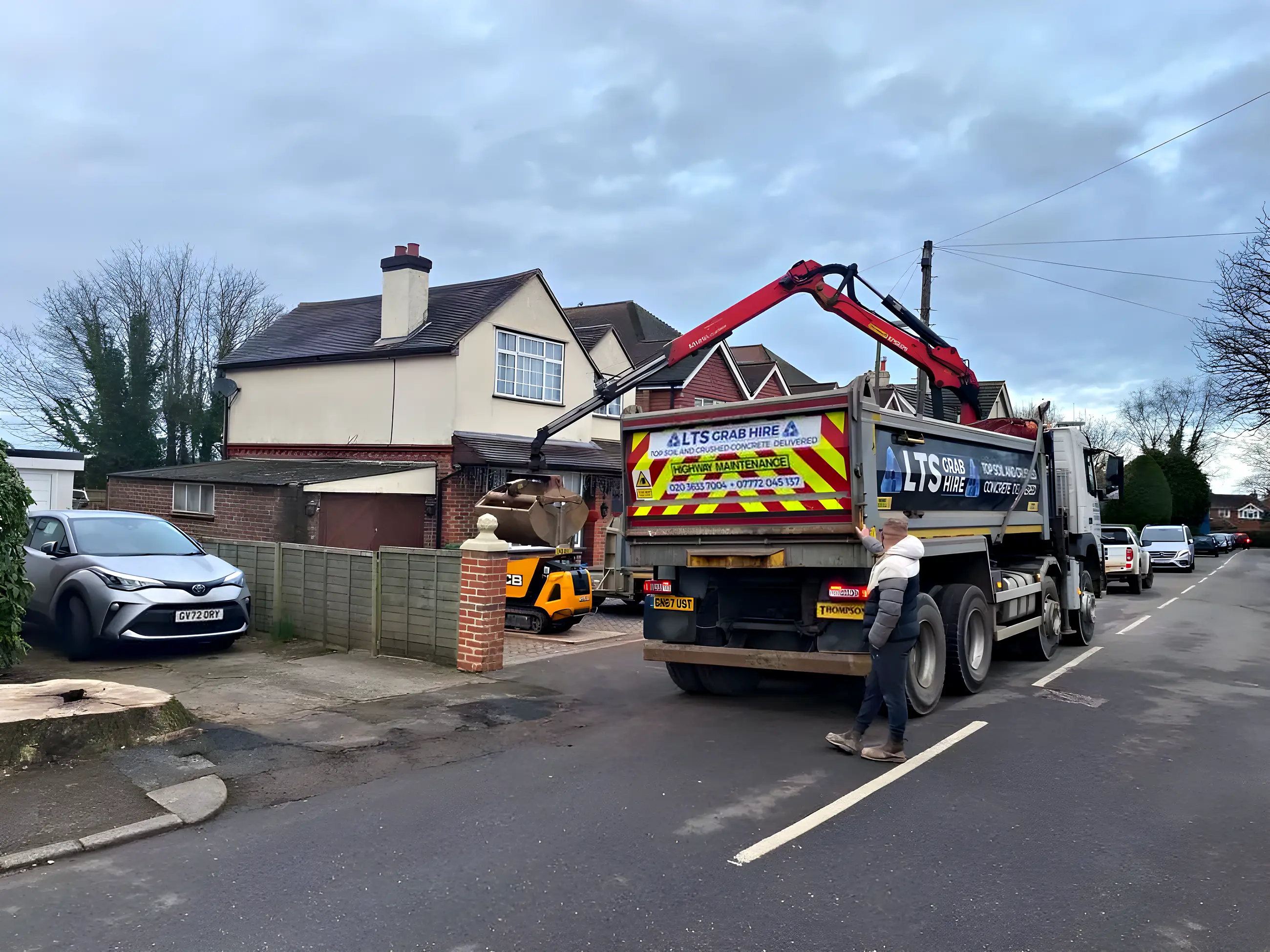 A grab lorry parked outside a house on a residential street