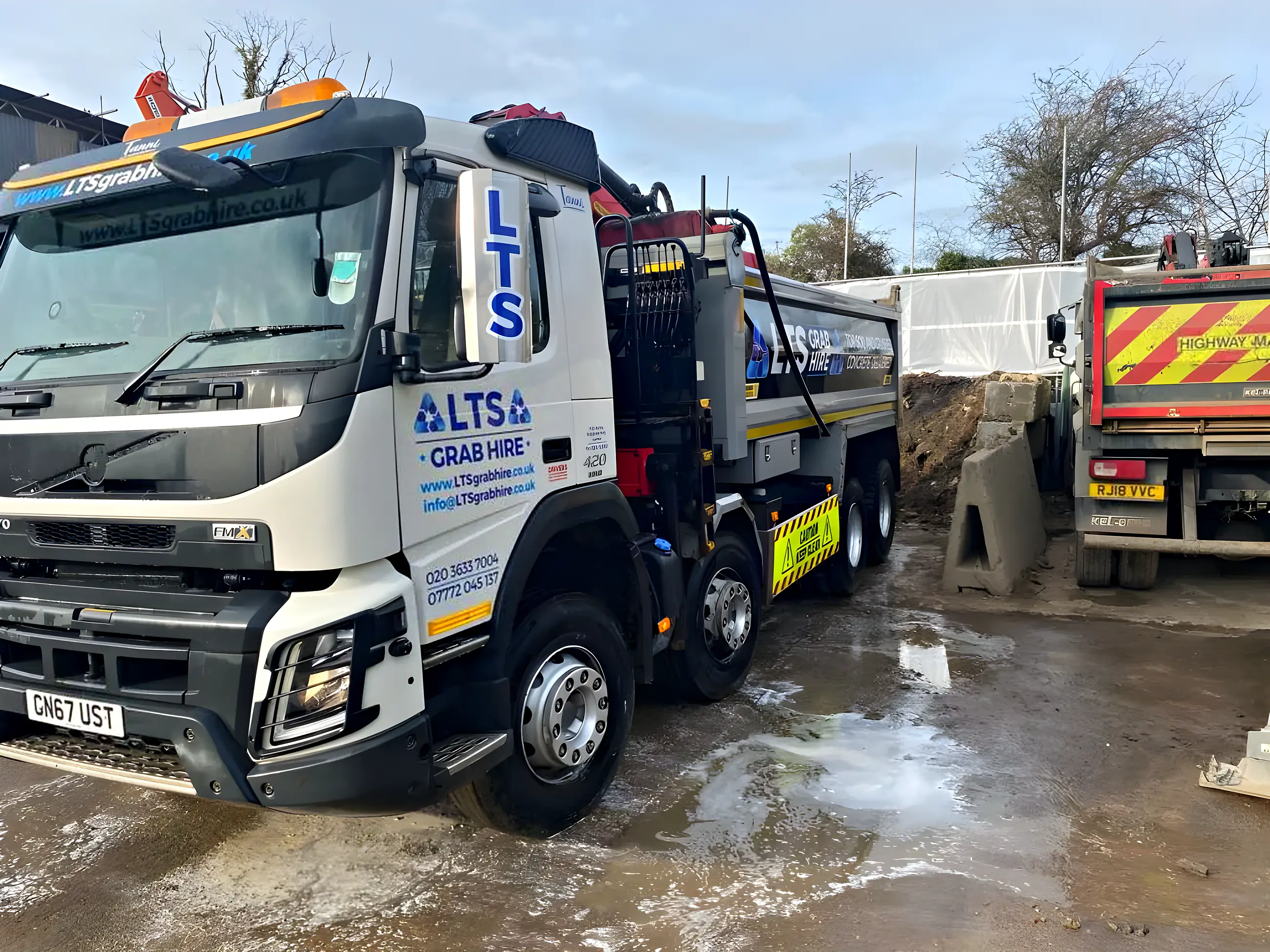 Two grab lorries loading at the yard